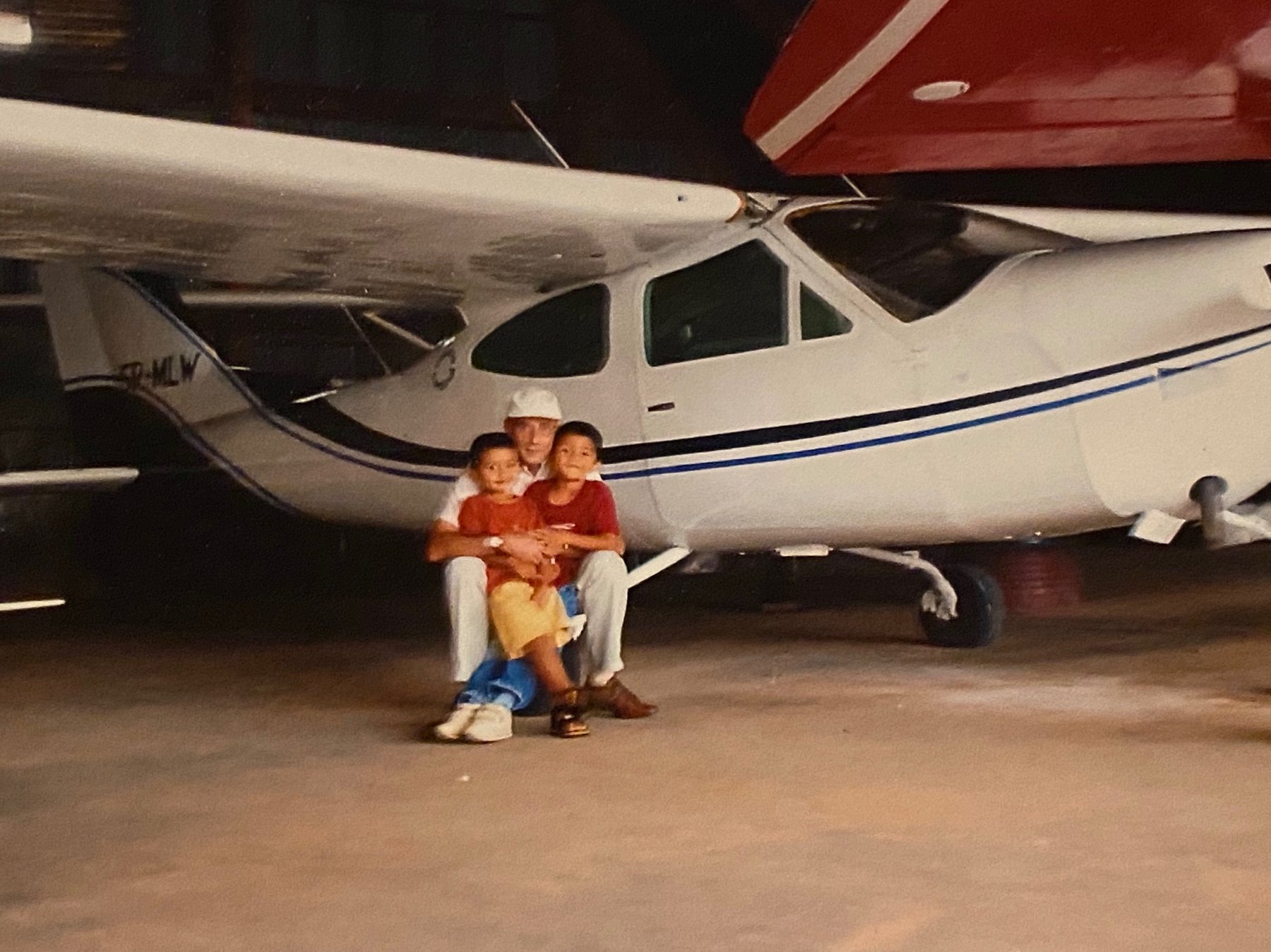 Deux enfants et leur père devant un avion